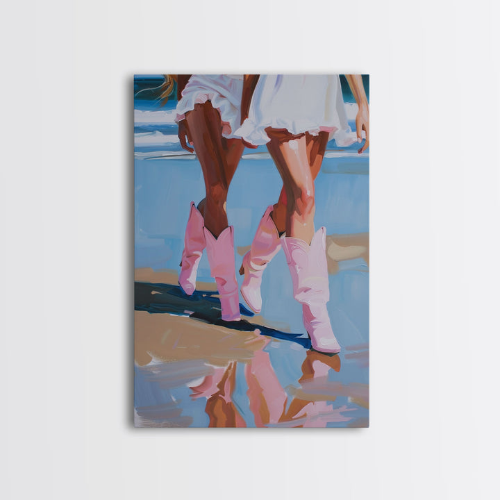 Two women wearing pink cowboy boots walking on the beach, reflections in sand Framed Canvas Print - beach decor, fashion art, summer vibes