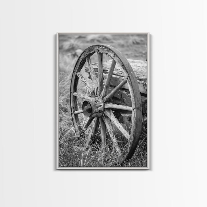 Weathered wagon wheel in tall grass, black and white photography, Framed Canvas Print, rustic Western decor, vintage wall art for home