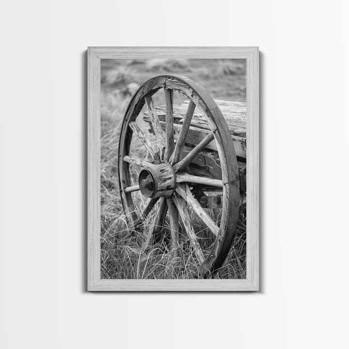 Weathered wagon wheel in tall grass, black and white photography, Framed Canvas Print, rustic Western decor, vintage wall art for home